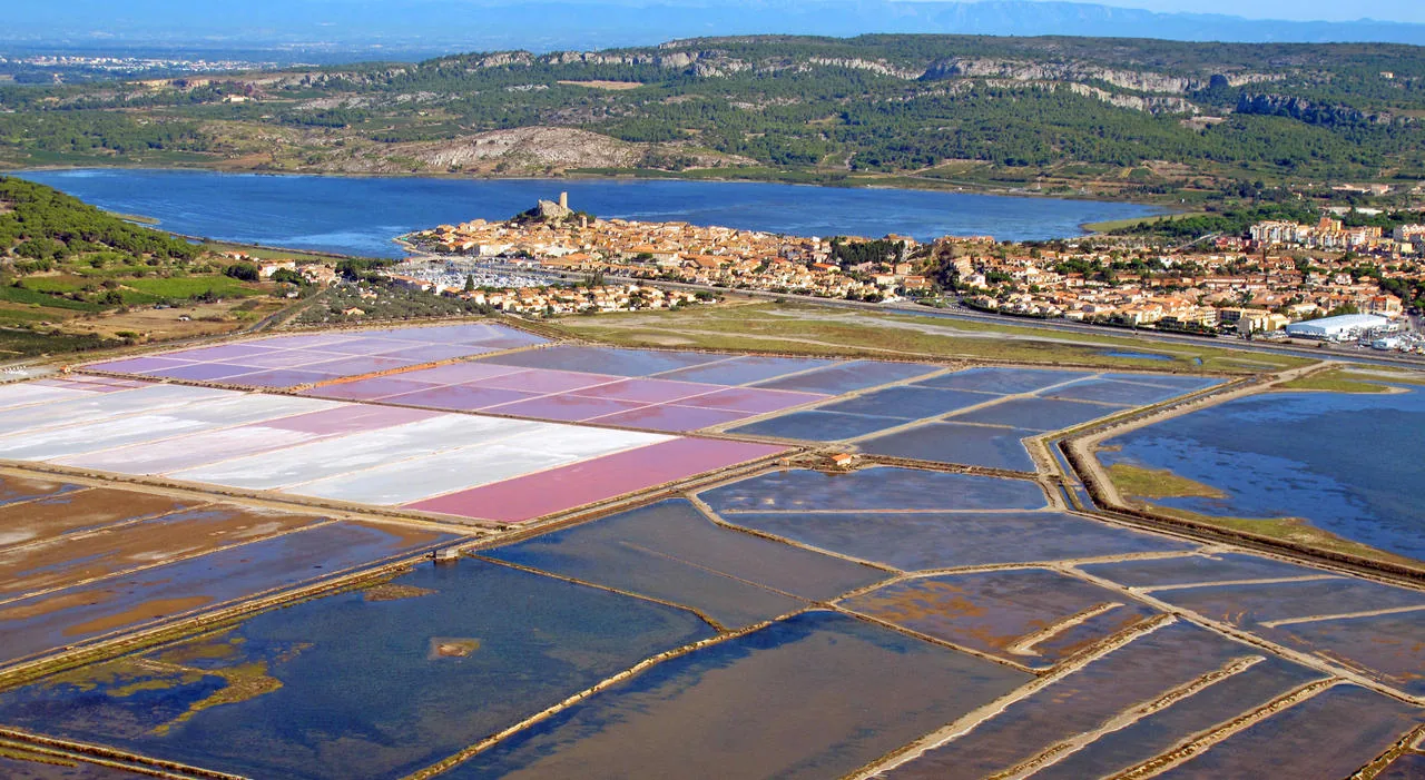Vue aérienne des salins de Gruissan aux bassins roses, avec le village et l'étang